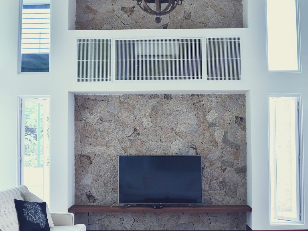 Double-height stone feature wall with mounted television