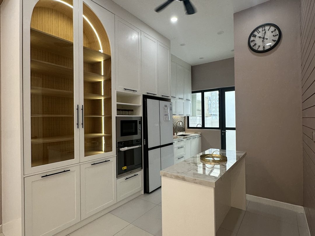 White shaker kitchen with an arched glass display cabinet and a marble waterfall island