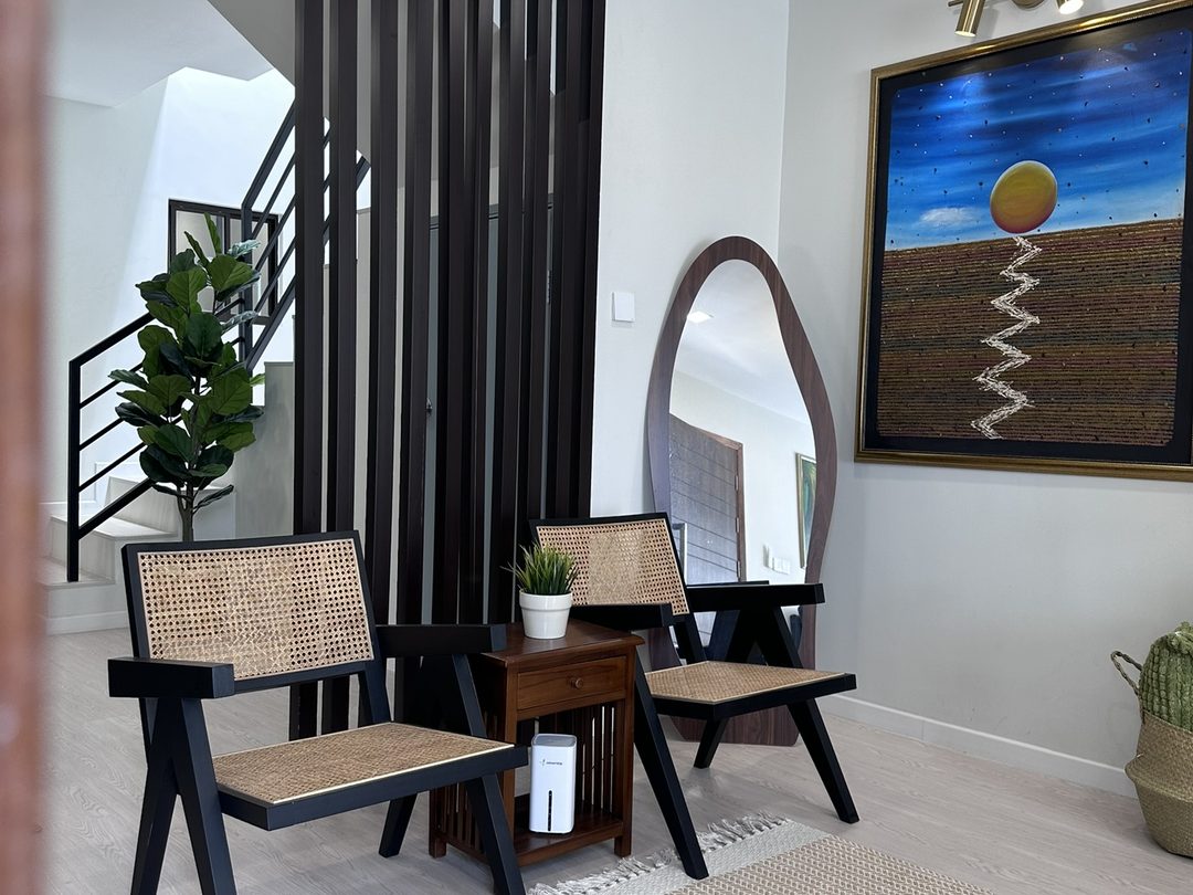 Sitting nook with rattan lounge chairs, arch mirror and timber slat screen