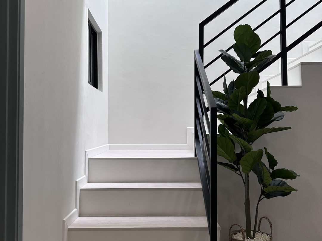 Staircase with black steel railing lit from a skylight