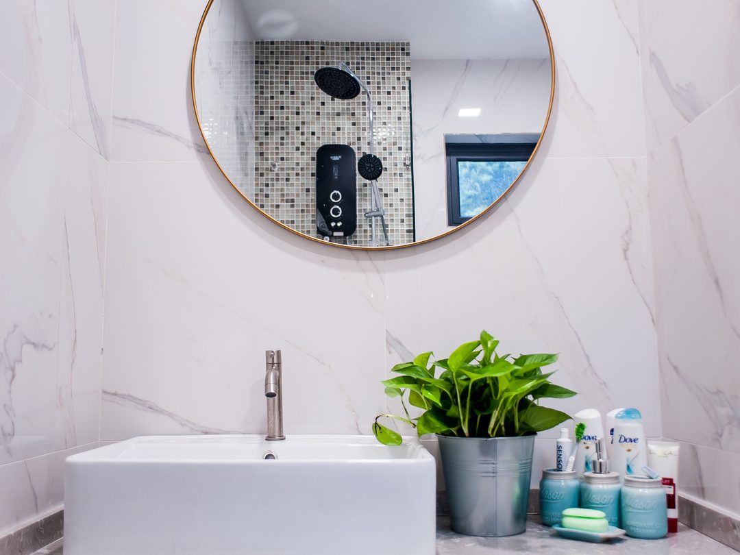 Bathroom vanity with brass-rimmed mirror