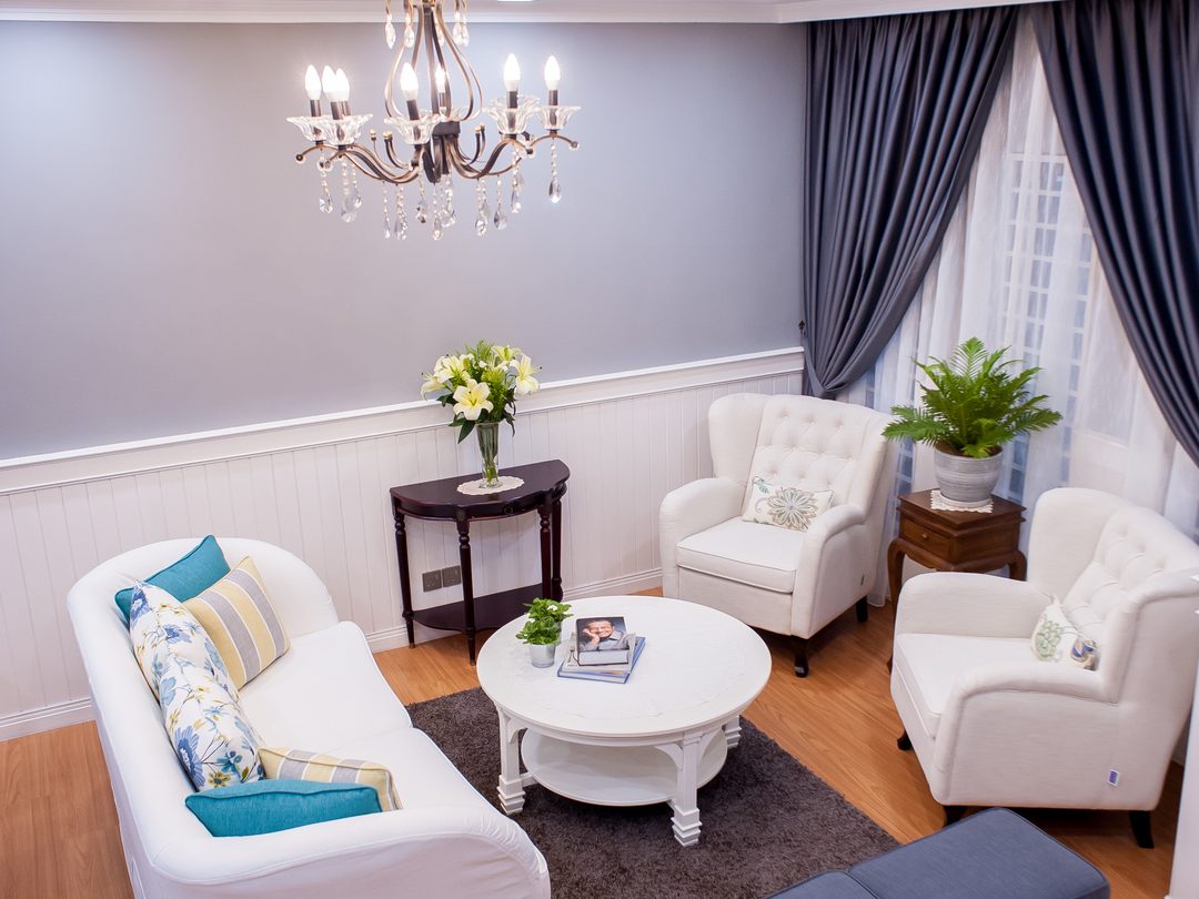 Sitting room with slip-covered sofas and ottoman